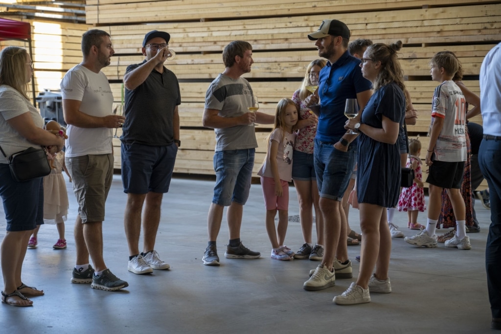 BesucherInnen genießen und unterhalten sich auf der 100-Jahre-Rubner-Feier in der holzius Heimstatt, umgeben von Vollholz.