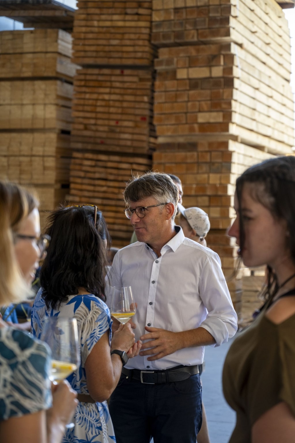 BesucherInnen genießen die 100-Jahre-Rubner-Feier in der holzius Heimstatt, umgeben von Vollholz.