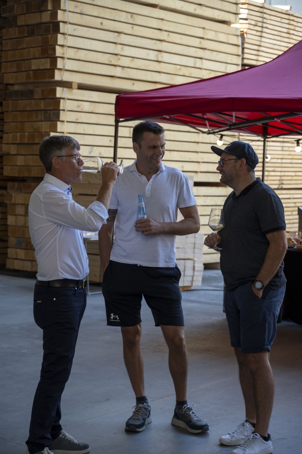 BesucherInnen genießen und unterhalten sich auf der 100-Jahre-Rubner-Feier in der holzius Heimstatt, umgeben von Vollholz.