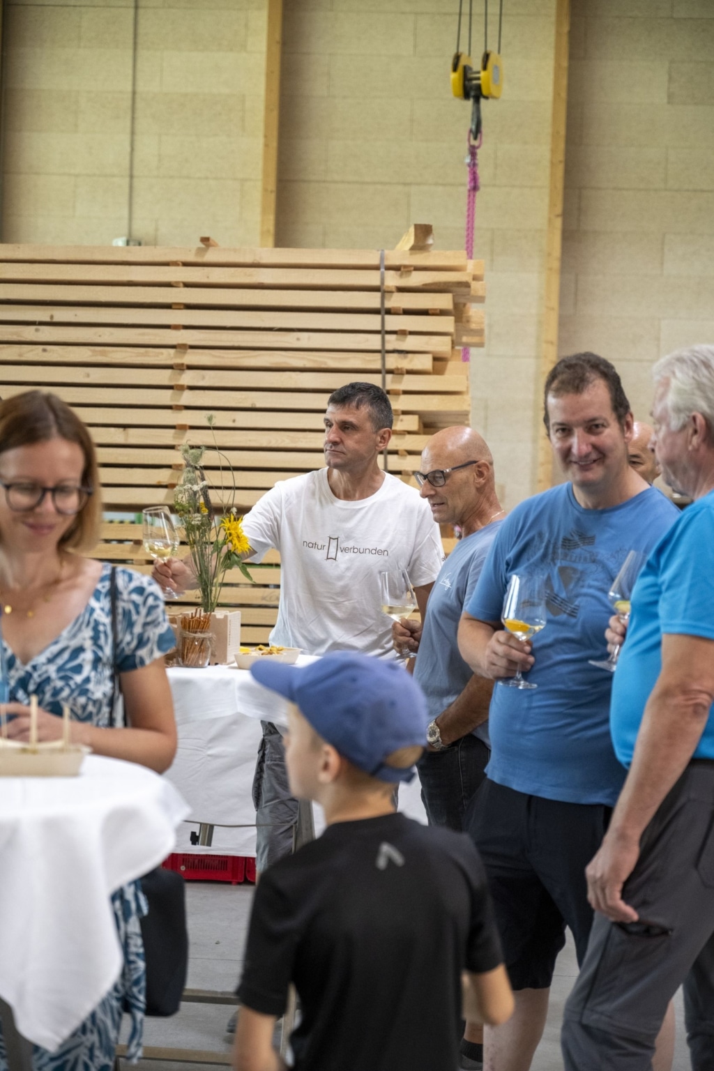 BesucherInnen genießen und unterhalten sich auf der 100-Jahre-Rubner-Feier in der holzius Heimstatt, umgeben von Vollholz.