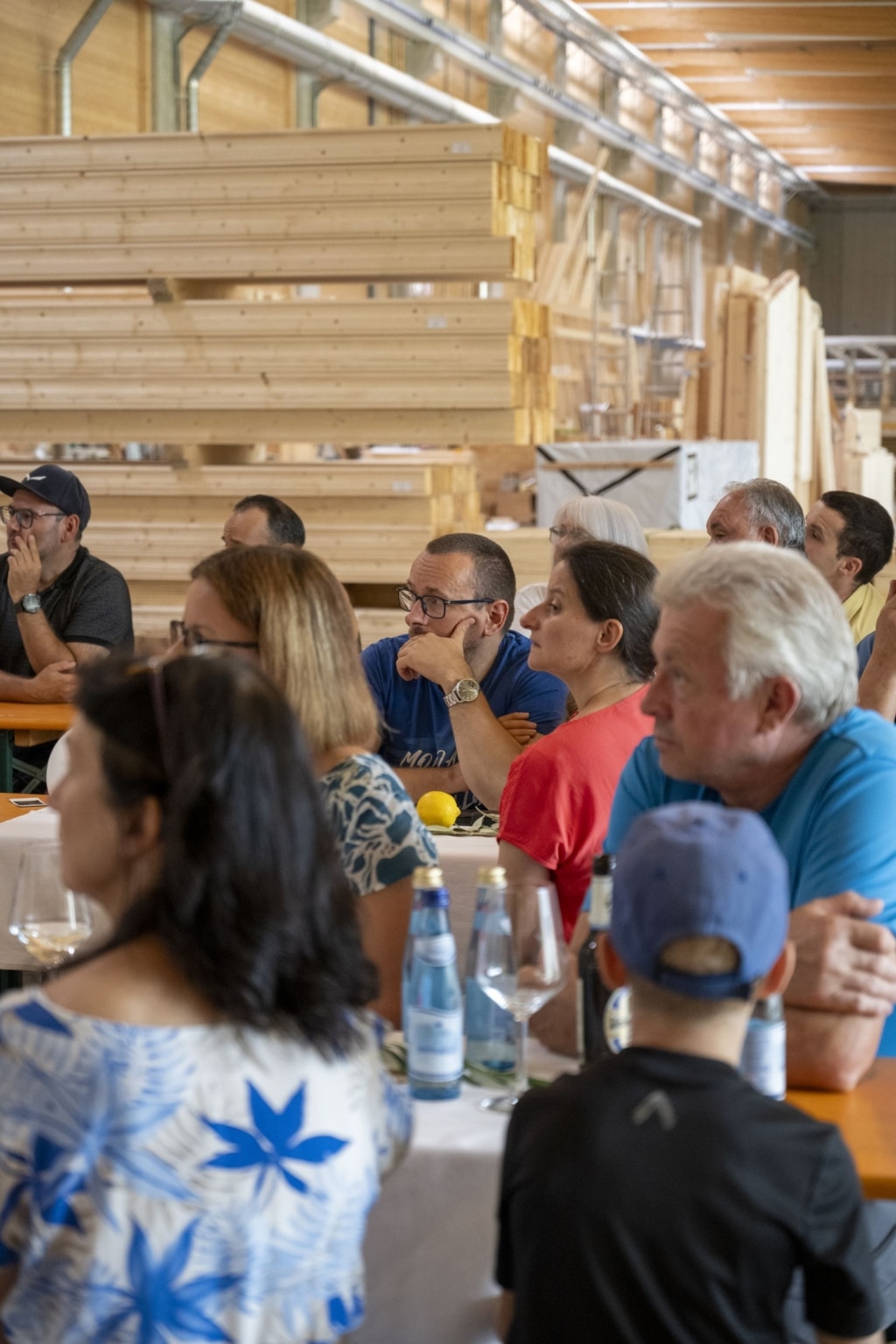 BesucherInnen genießen und unterhalten sich auf der 100-Jahre-Rubner-Feier in der holzius Heimstatt, umgeben von Vollholz.