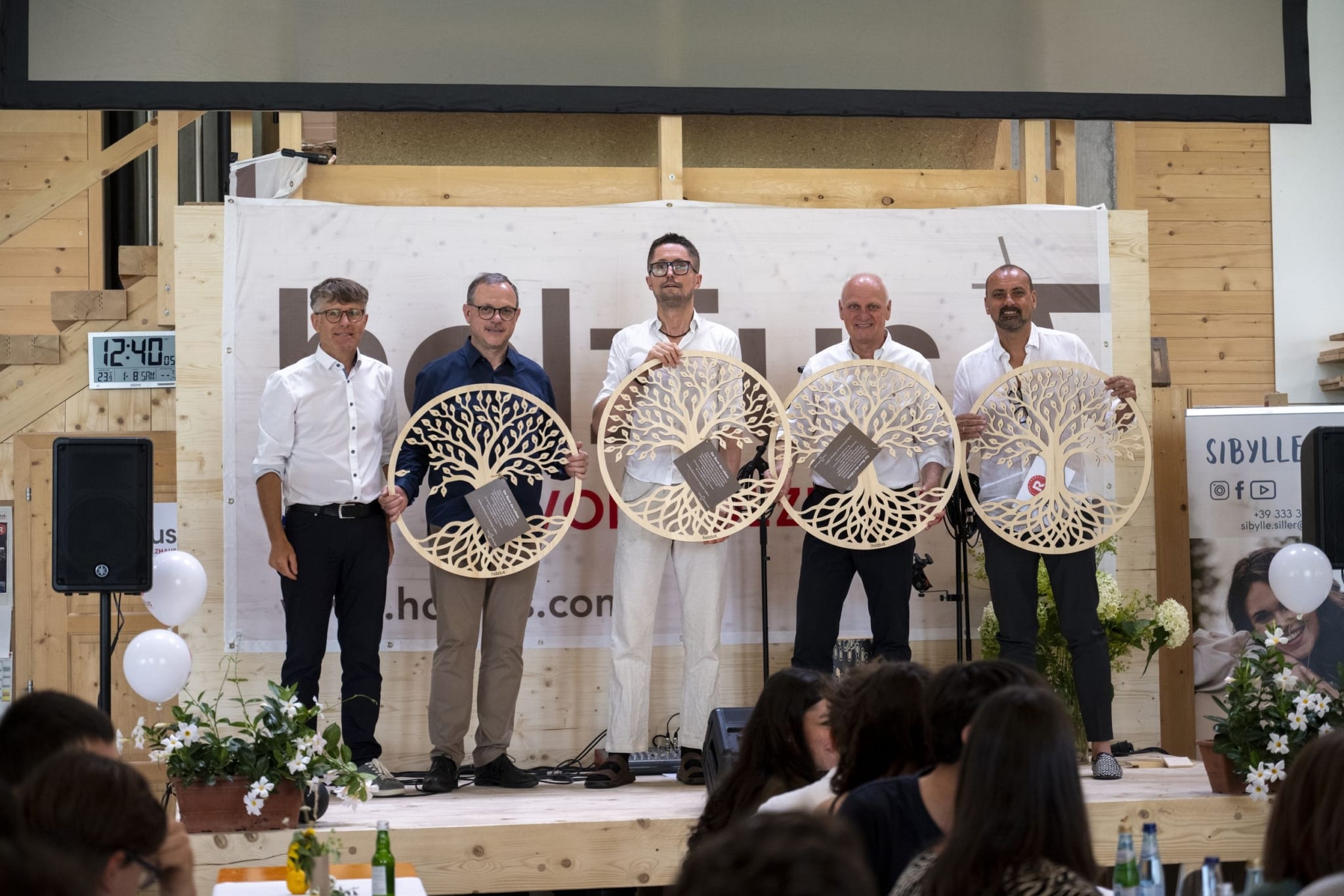 Gruppenbild von Herbert Niederfriniger, Joachim Rubner, Matthias Rubner, Peter Rubner und Stefan Rubner. Die 4 Rubner halten einen hölzernen Lebensbaum in der Hand.
